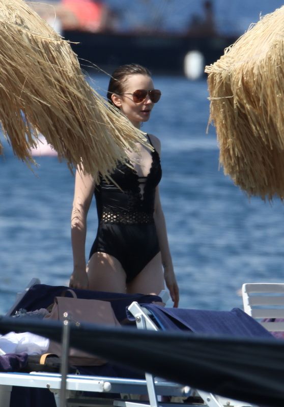 Lily Collins Candids - in Black Swimsuit at the Beach in Italy 07/15/2017