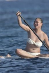 Chrissy Teigen in Bikini - Paddle Boarding in Sardinia 08/30/2017
