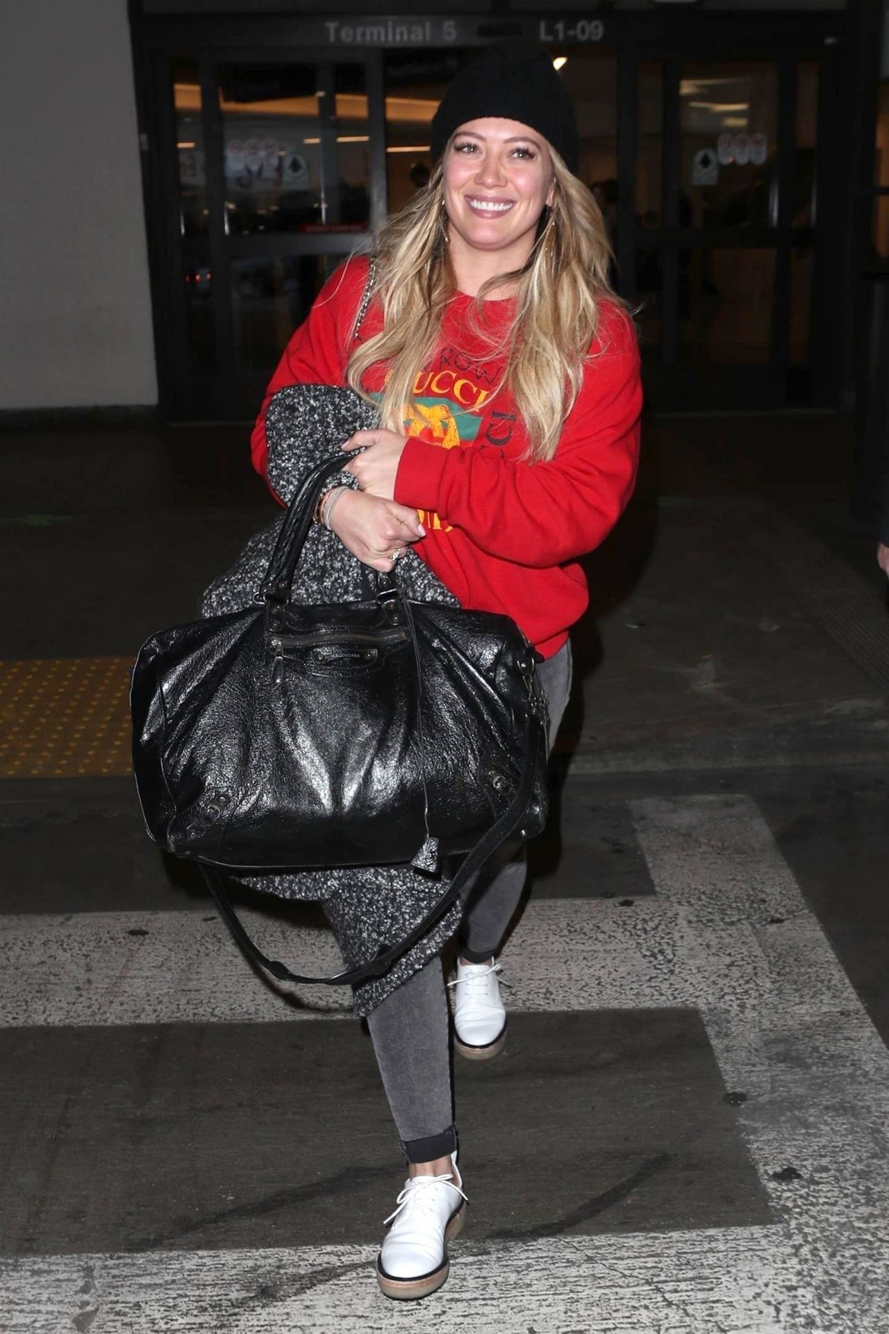 Hilary Duff departs from the airport carrying luggage from Louis