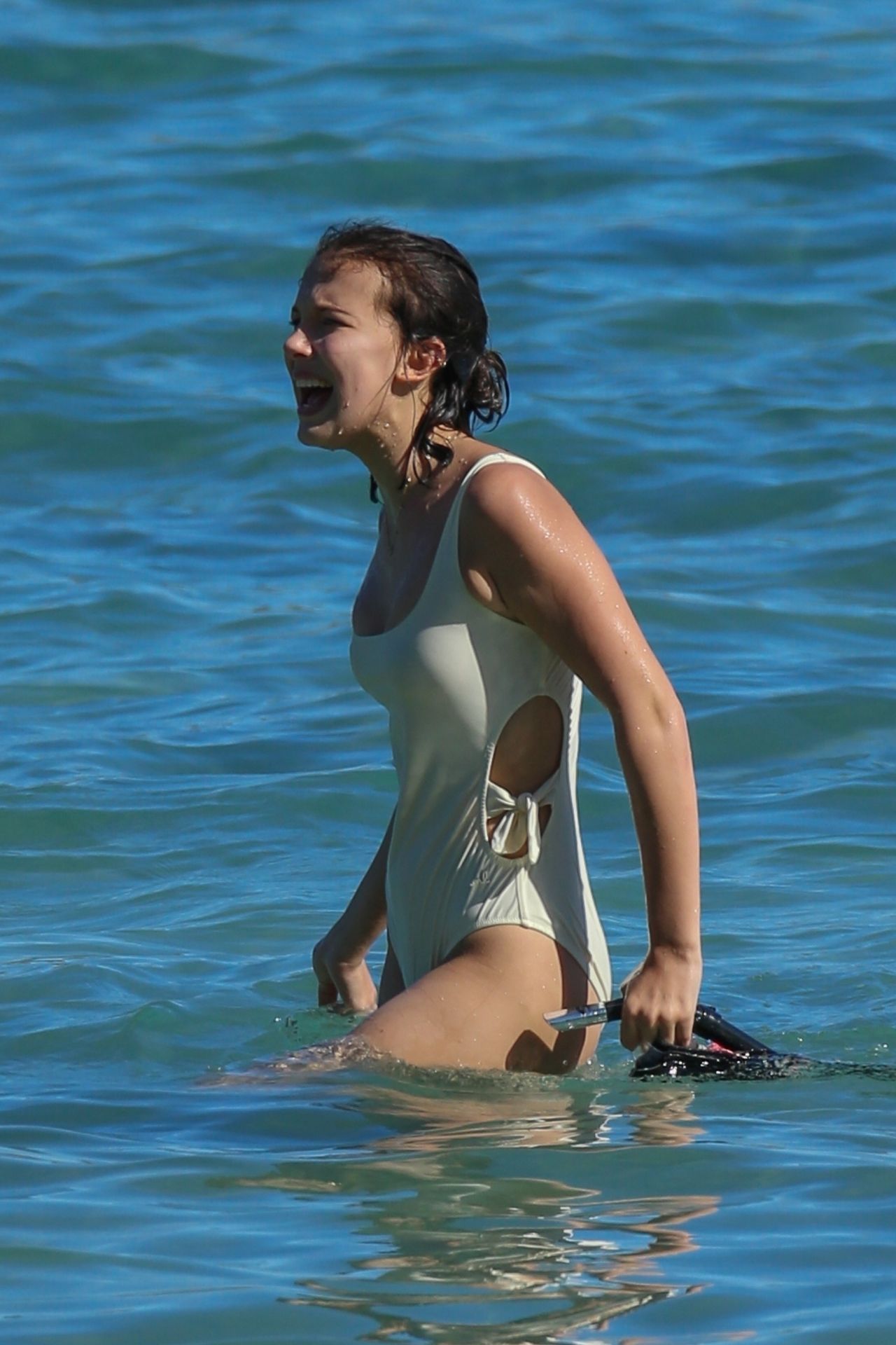 Millie Bobby Brown in White Swimsuit on the beach in 