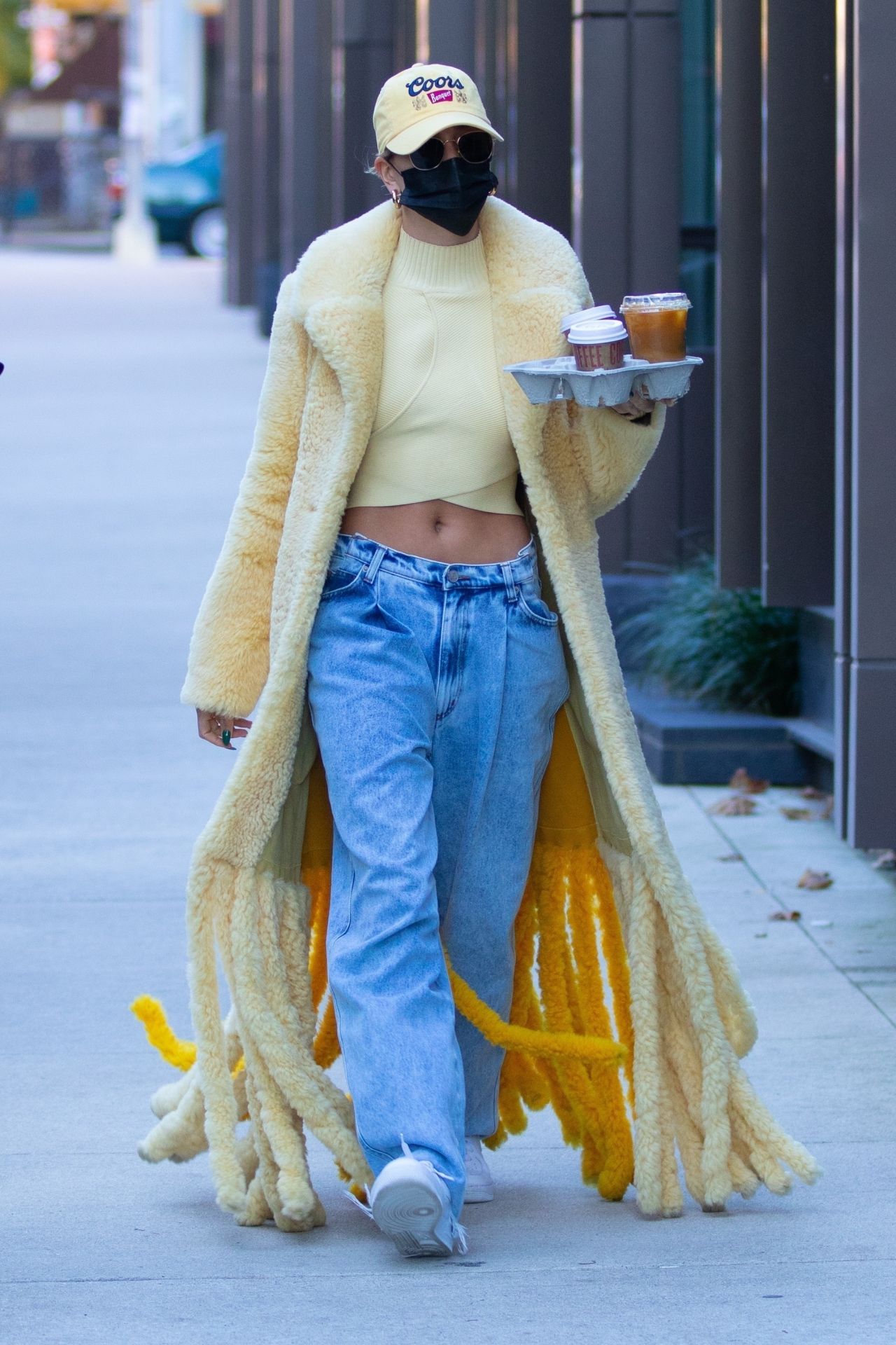 Hailey Bieber in a Thick, Fuzzy Yellow Coat and Pair of Baggy Acid Wash