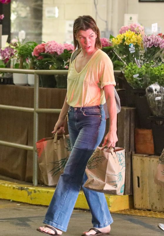 Milla Jovovich in Jeans and a Yellow V-neck T-shirt at Whole Foods in Beverly Hills 09/20/2022
