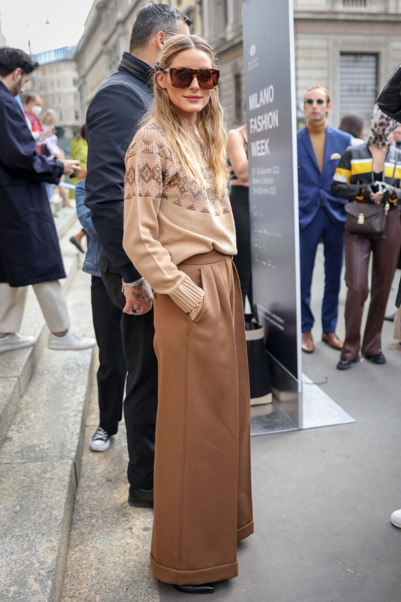 Olivia Palermo is seen wearing plaid pants, beige knit outside