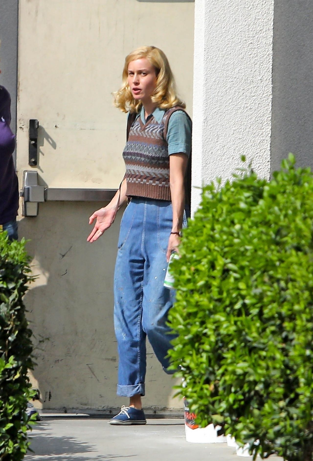 Brie Larson cute on set in nerdy sweater and jeans