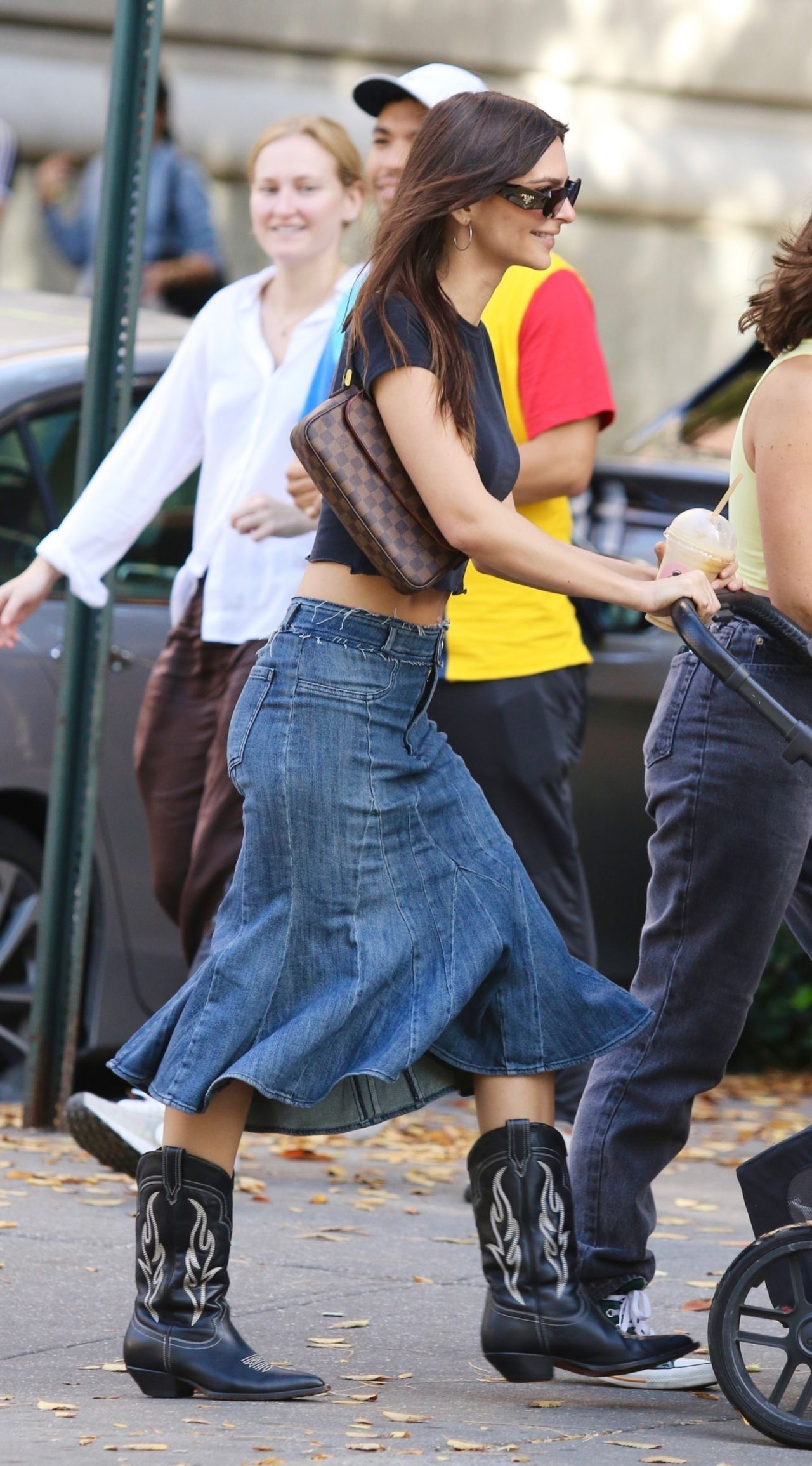 Emily Ratajkowski Pairs A Denim Skirt with Cowboy Boots with Her