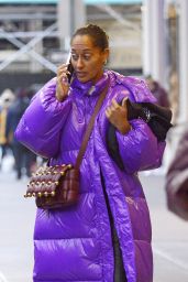 Tracee Ellis Ross Wearing a Long Purple Bubble Coat, Black Pants, White Sneakers and Brown Leather Shoulder Bag 12/21/2022