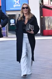 Amanda Holden in a Sizzling Black Satin Shirt With High-Waist White Flared Trousers and Black Stiletto Heels 03/24/2023