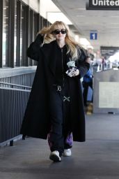 Kathryn Newton in a Black Coat and Sunglasses at LAX in Los Angeles 04/03/2023