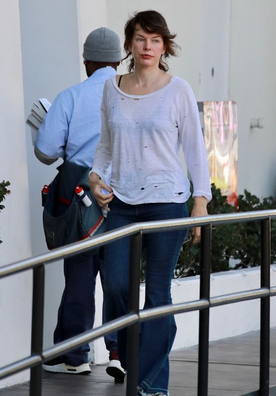 Milla Jovovich in a Distressed White Top Paired With Some Flared Blue Jeans in Los Angeles 01/13/2024