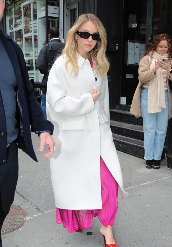 Sydney Sweeney in a White Coat, Pink Dress and Red Heels Leaves a Bai Event in New York 03/07/2024