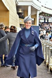 Zara Tindall Wearing a Long Blue Coat and a Gray and Extravagant Hat on Day One of the Cheltenham Race Festival 03/12/2024