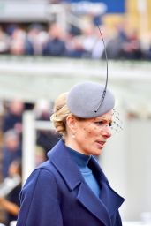 Zara Tindall Wearing a Long Blue Coat and a Gray and Extravagant Hat on Day One of the Cheltenham Race Festival 03/12/2024