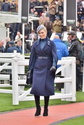 Zara Tindall Wearing a Long Blue Coat and a Gray and Extravagant Hat on Day One of the Cheltenham Race Festival 03/12/2024