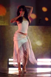 Camila Cabello performing in a white lace corset and fringed skirt at Coachella in Indio, April 2026