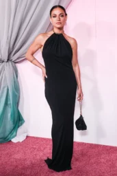 Inanna Sarkis posing in a black halter gown with chunky gold collar necklace and chain bag at Fashion Trust U.S. Awards in Los Angeles April 2026
