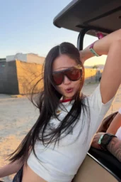 Jennie Kim posing in graphic T shirt and denim skirt at Revolve Festival April 11 2026