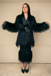 Michelle Dockery posing in a black fringed belted outfit with pointed black shoes for British Airways High Life Magazine photoshoot, September 2025