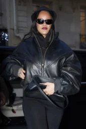 Rihanna walking in Paris in an oversized dark leather jacket and black sunglasses, April 2026