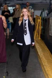 Milly Alcock walking in Midtown New York in Thom Browne suiting and polka-dot tie, June 2026